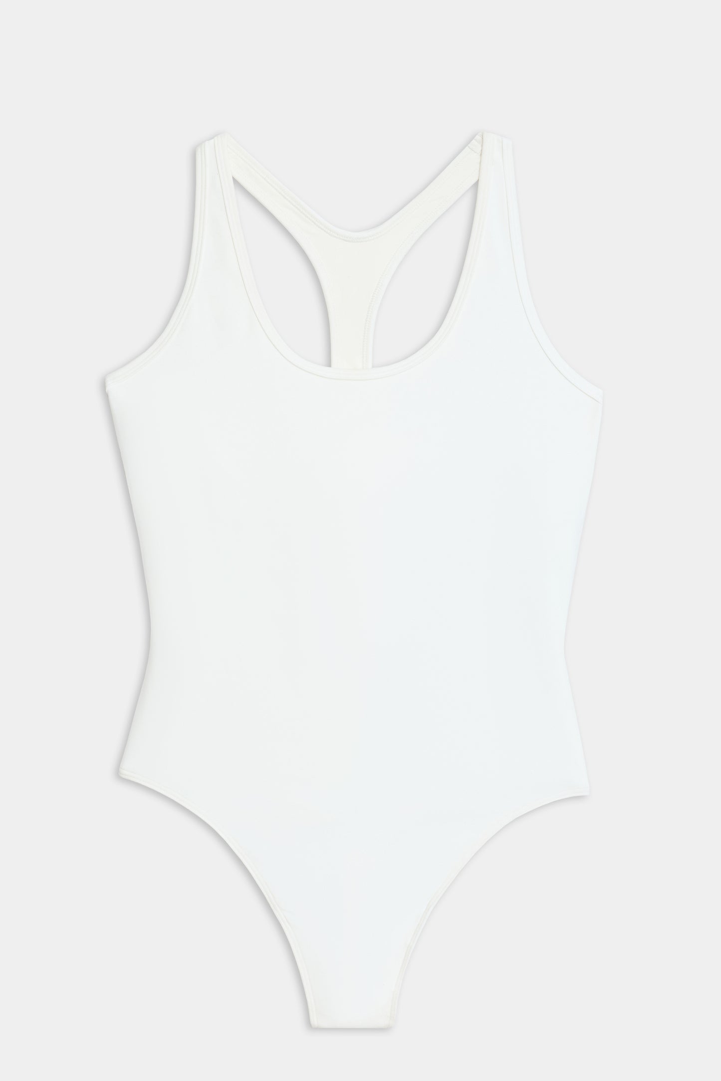 The SPLITS59 Suki Airweight Bodysuit in white is a soft nylon-spandex one-piece with a racerback design, shown on a flat white background.