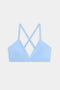 The SPLITS59 Theo Rigor Bra features a light blue shade with thin straps and a crisscross back design, showcased against a plain white background.