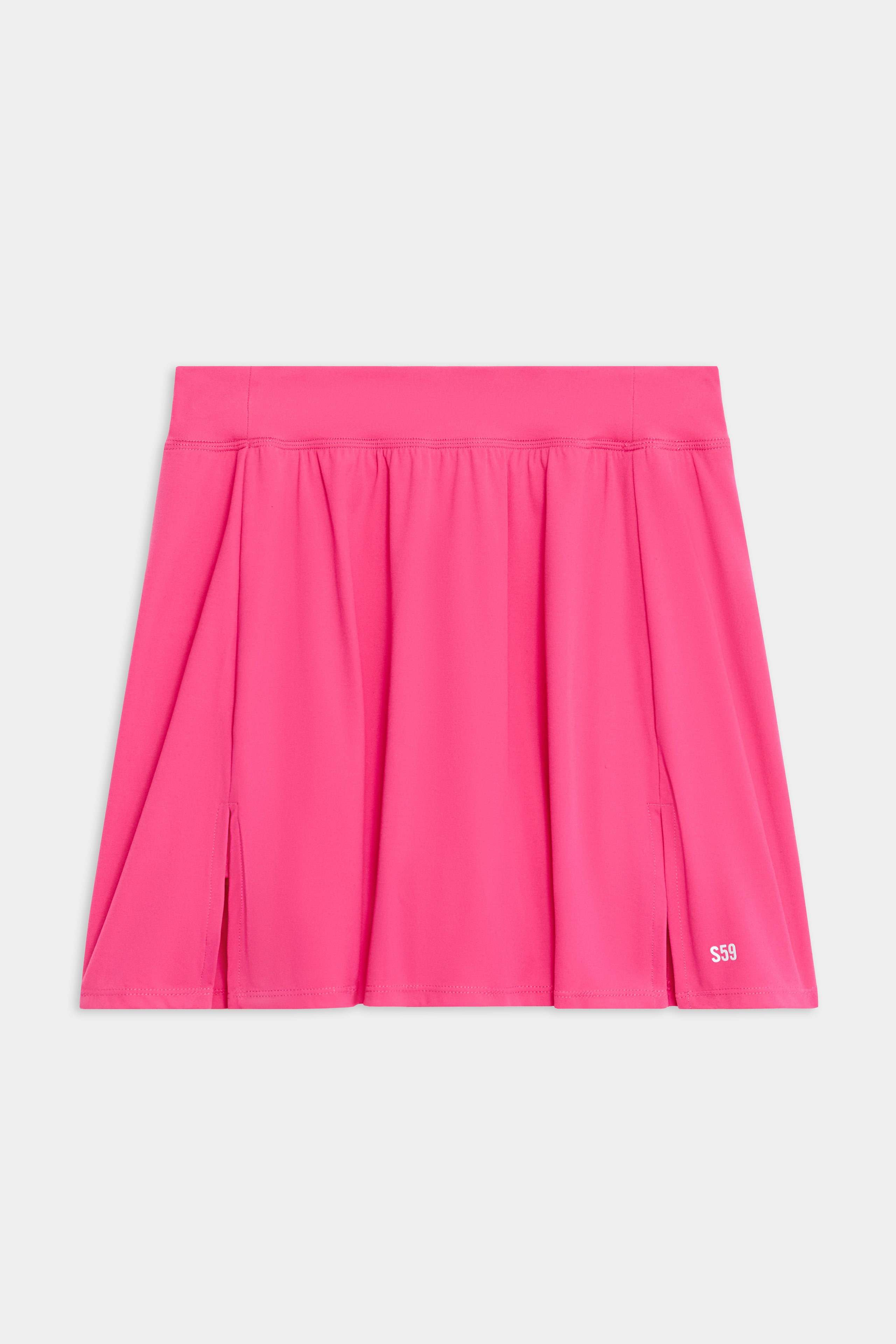 The Venus High Waist Rigor Skort by SPLITS59 is a bright pink piece featuring pleats, a wide waistband, and small slits.