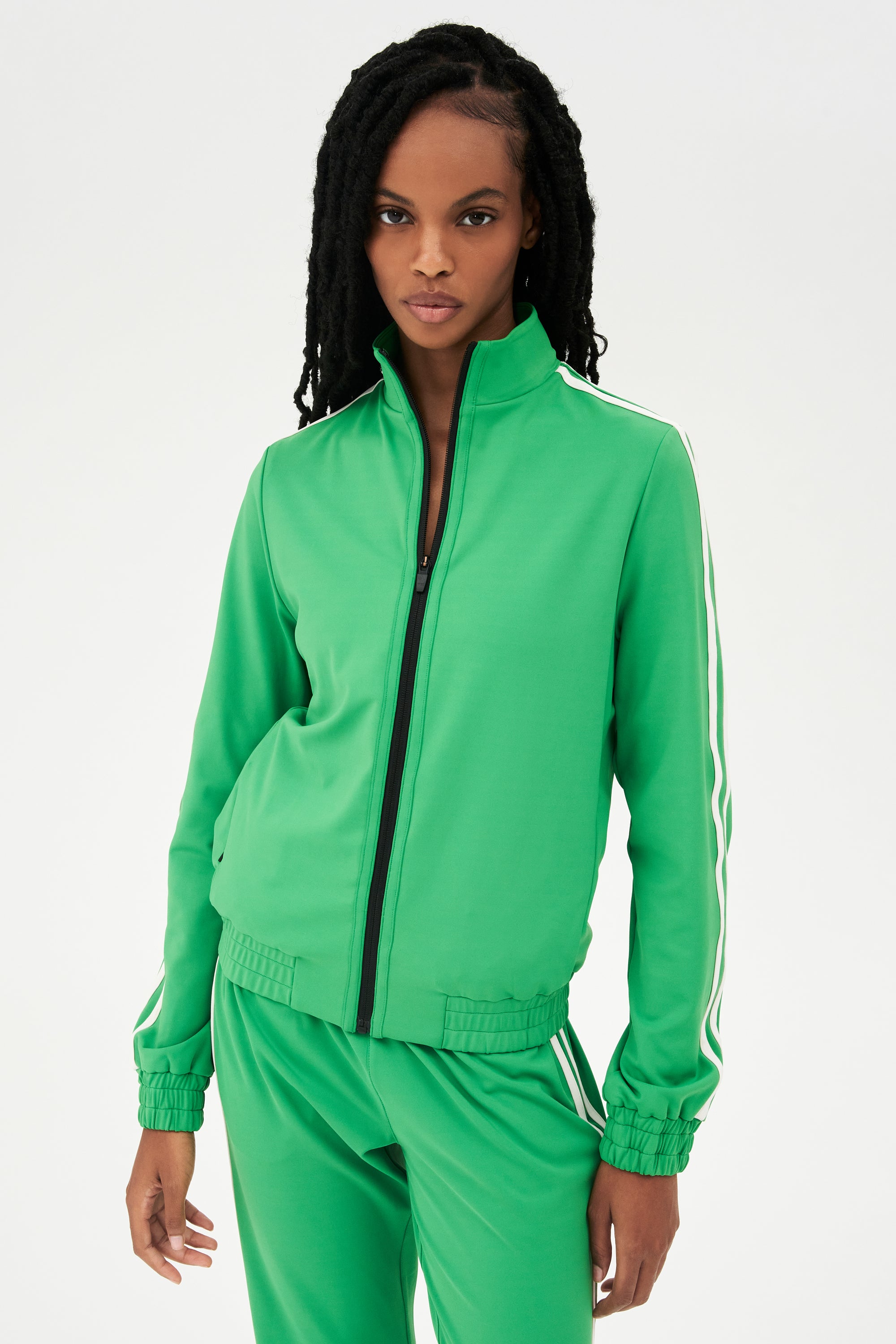 Woman wearing a SPLITS59 Fox Techflex Jacket in Grass/Vintage White with stripes posing against a white background.