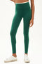 Frot view of girl wearing green leggings with thin white band around waist with white shoes