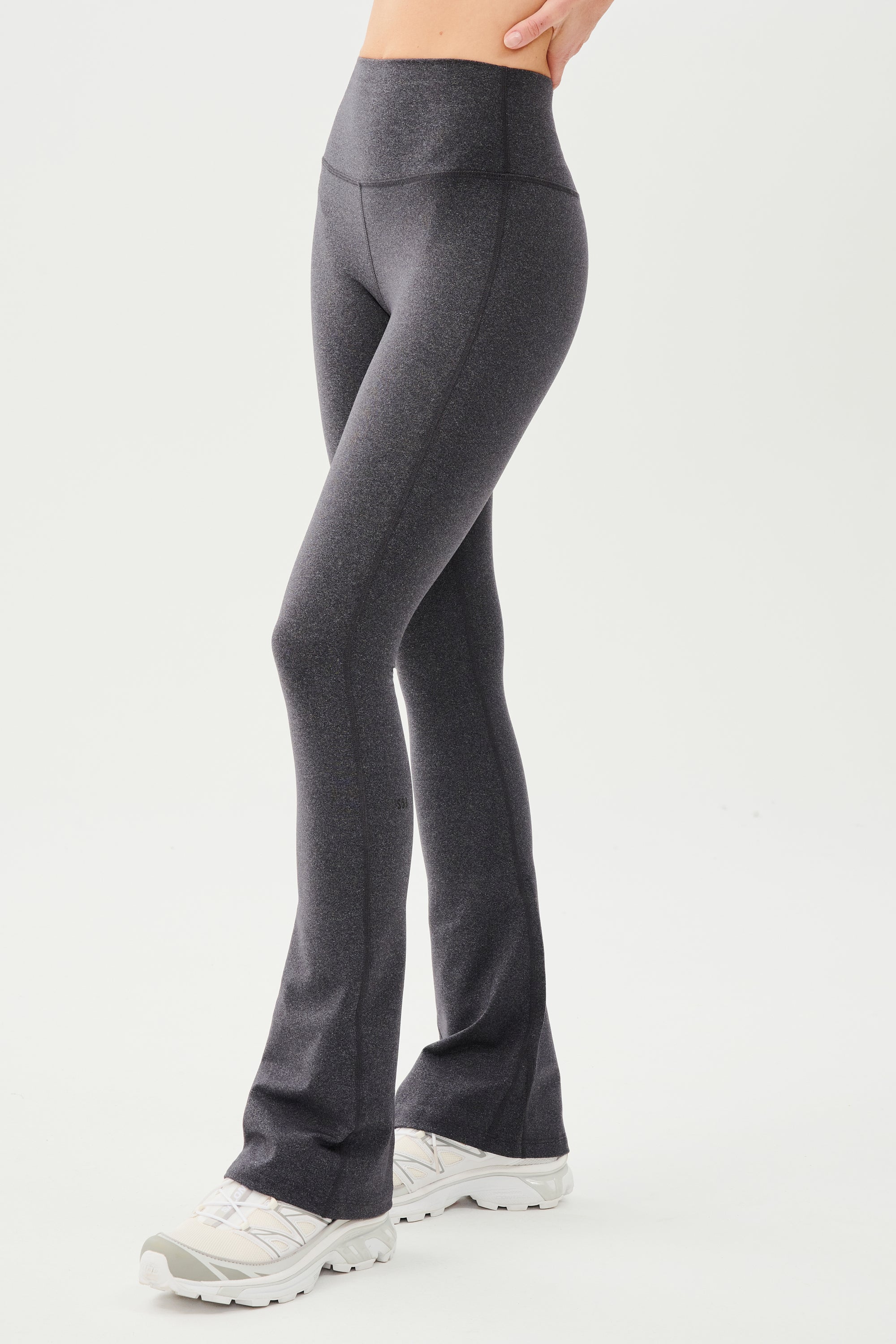 A woman wearing a Raquel High Waist Flared Legging in Heather Grey by SPLITS59.