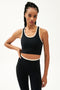 Front view of girl wearing cropped black tank top with white trim and black leggings with a thin white waistband