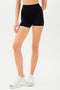 Half back view of girl wearing black shorts and white shoes