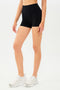 Half view of girl wearing black shorts and white shoes