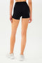 Half back view of girl wearing black shorts and white shoes